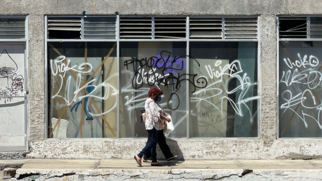 Women Walking in Front of a Deserted Storefront, La Paz Mexico